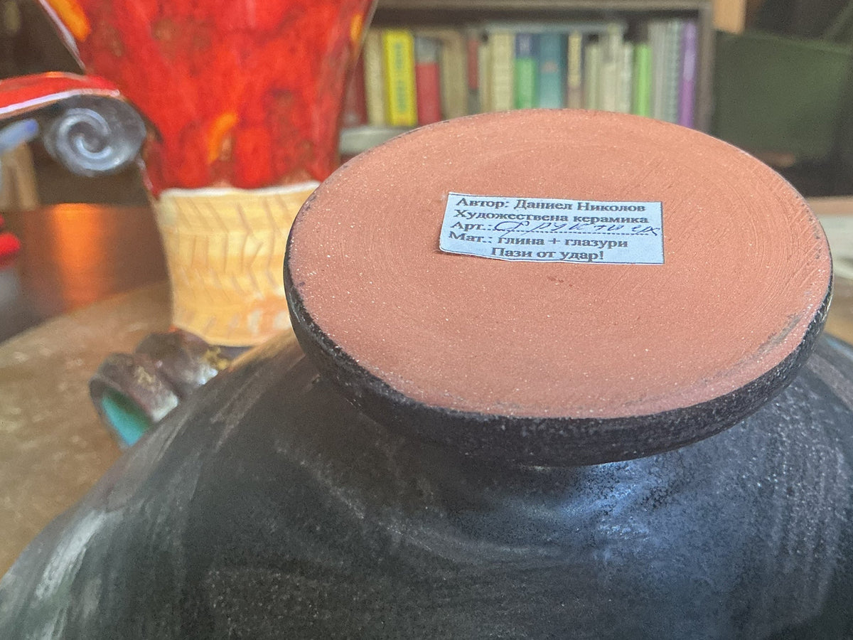 Otoch handcrafted ceramic bowl base with artist label by Daniel Nikolov showing terracotta clay and black glaze