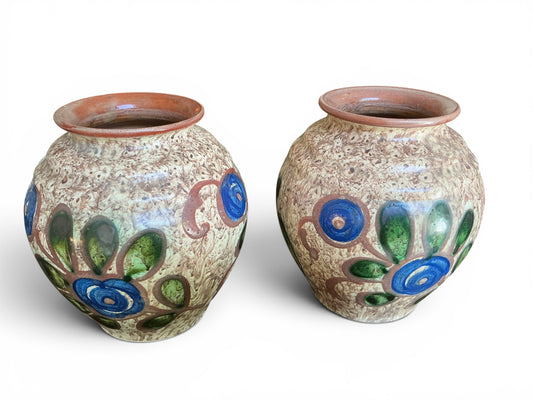 Otoch pair of handcrafted Swedish ceramic vases with mottled earthy glaze and vibrant blue and green floral motifs.