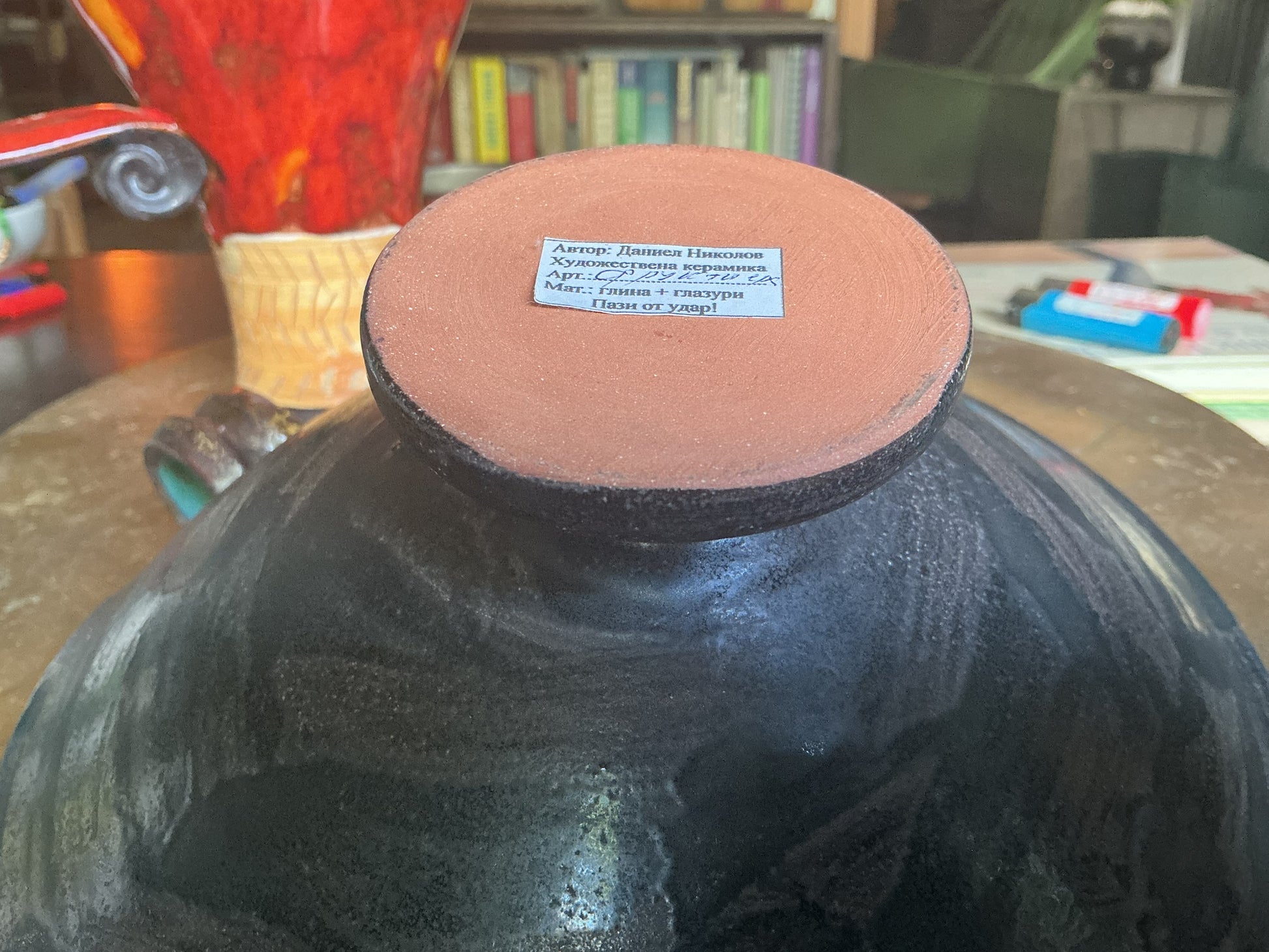 Otoch handcrafted ceramic bowl base with artist label by Daniel Nikolov showing terracotta clay and black glaze
