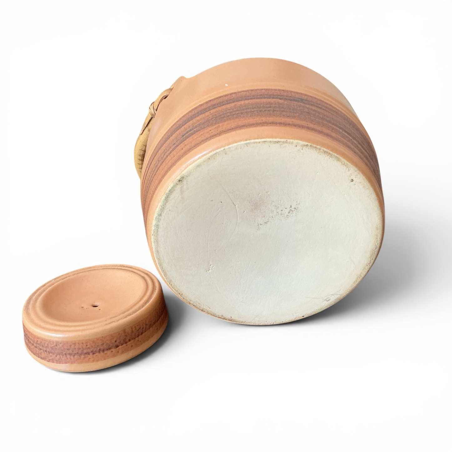 Otoch tan ceramic teapot with woven handle and lid, featuring horizontal bands and a ribbed lid.