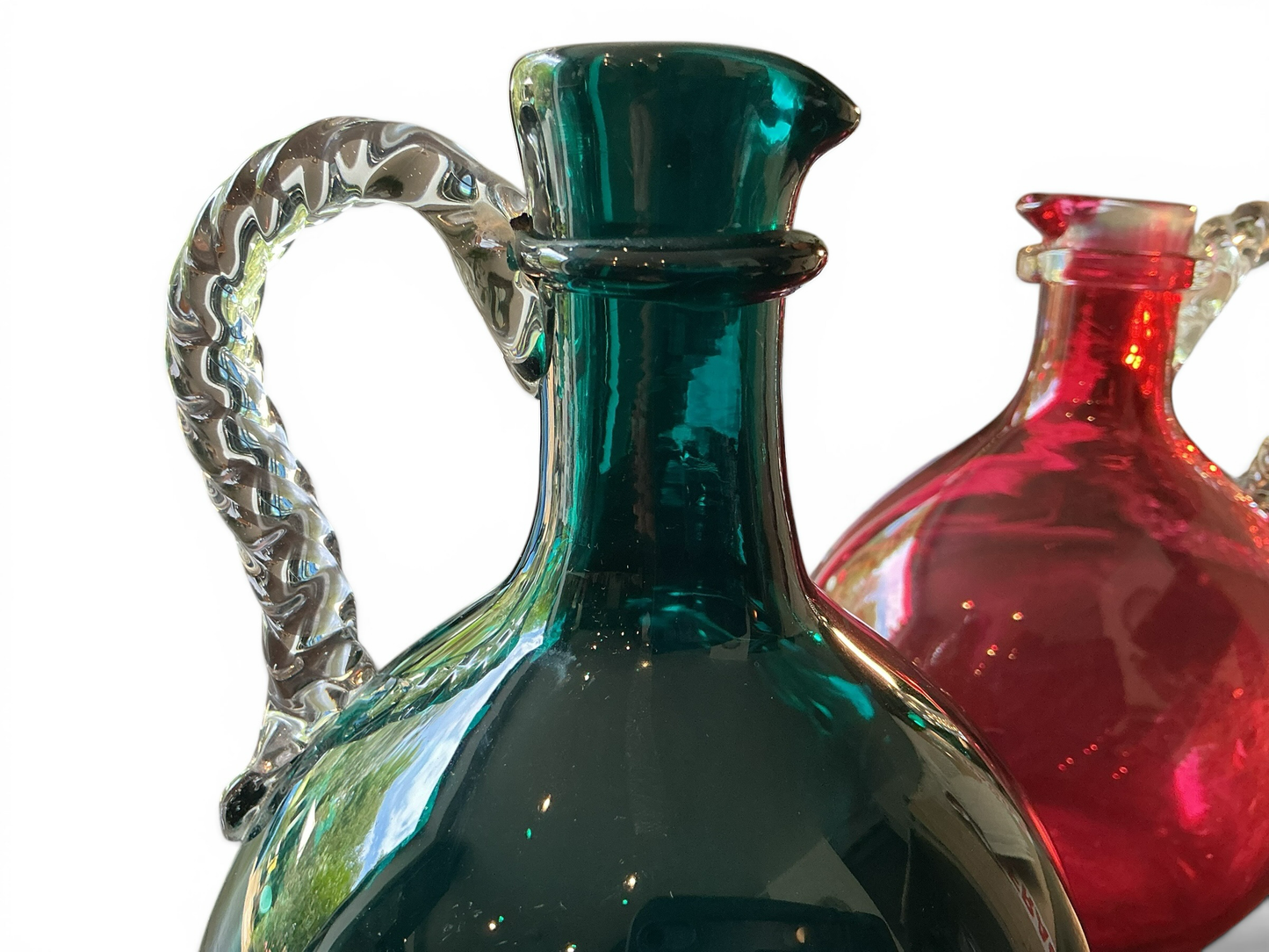 Otoch hand blown glass decorative pitcher set in emerald green and ruby red with clear twisted glass handles.