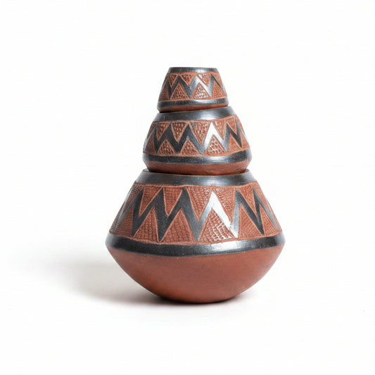 Otoch handcrafted terracotta nesting bowls with metallic zigzag patterns stacked on a dark wooden table.
