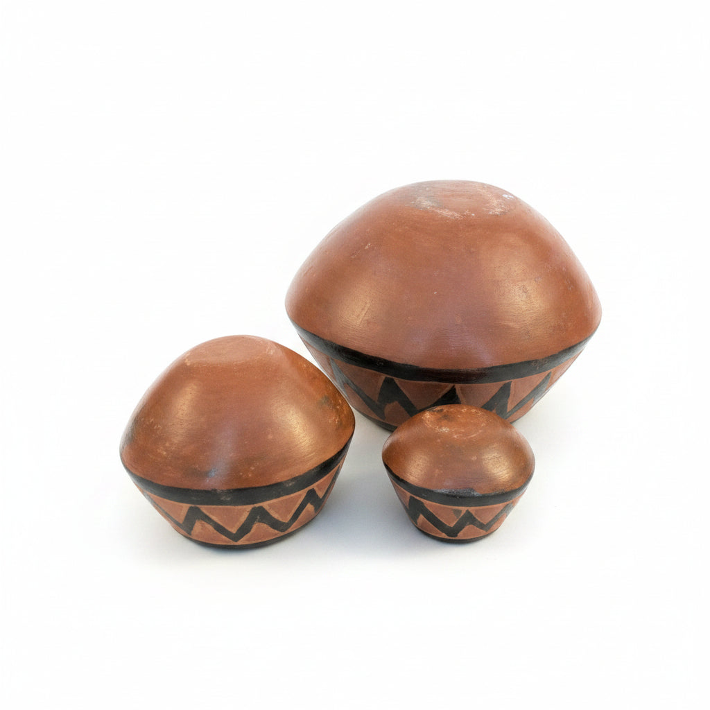 Otoch handcrafted terracotta nesting bowls with metallic geometric zigzag patterns on a dark wooden table.