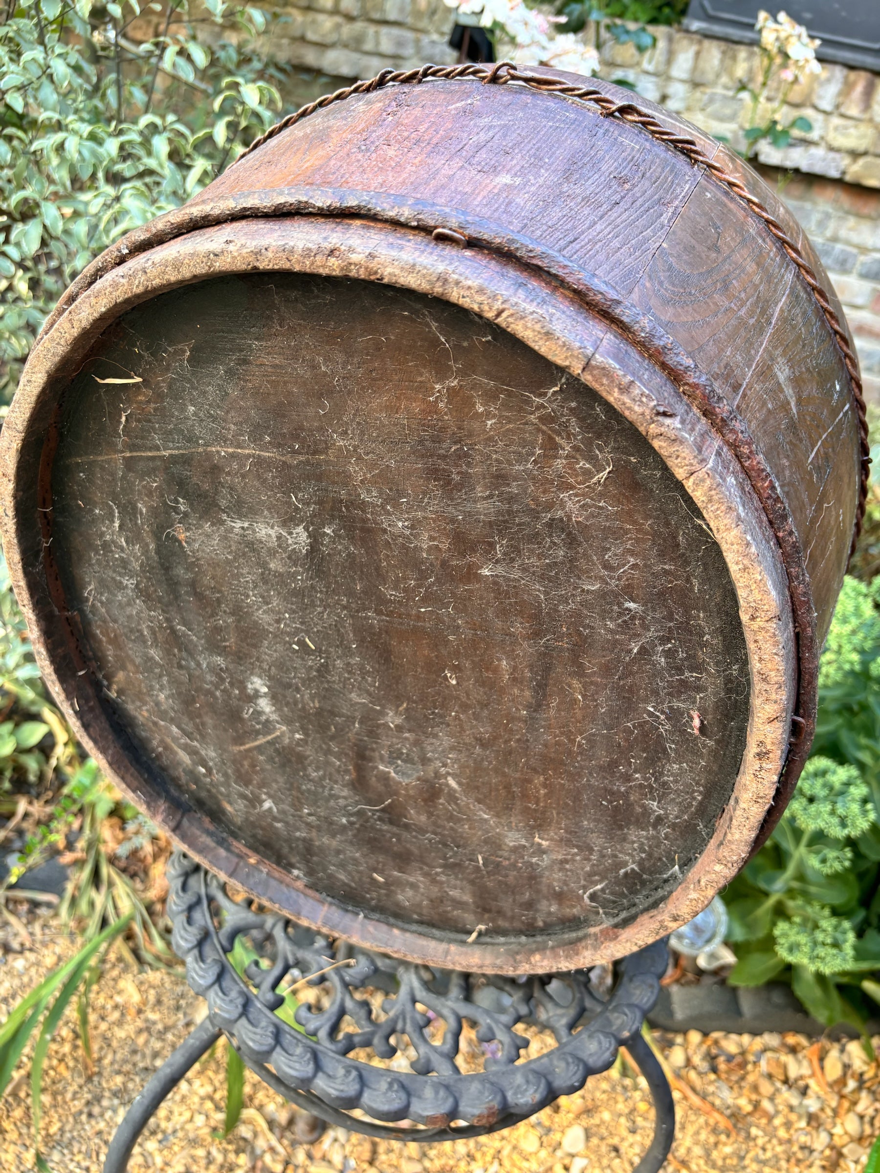 Otoch vintage handcrafted wooden bucket with dark weathered patina and twisted metal wire detailing in a garden setting